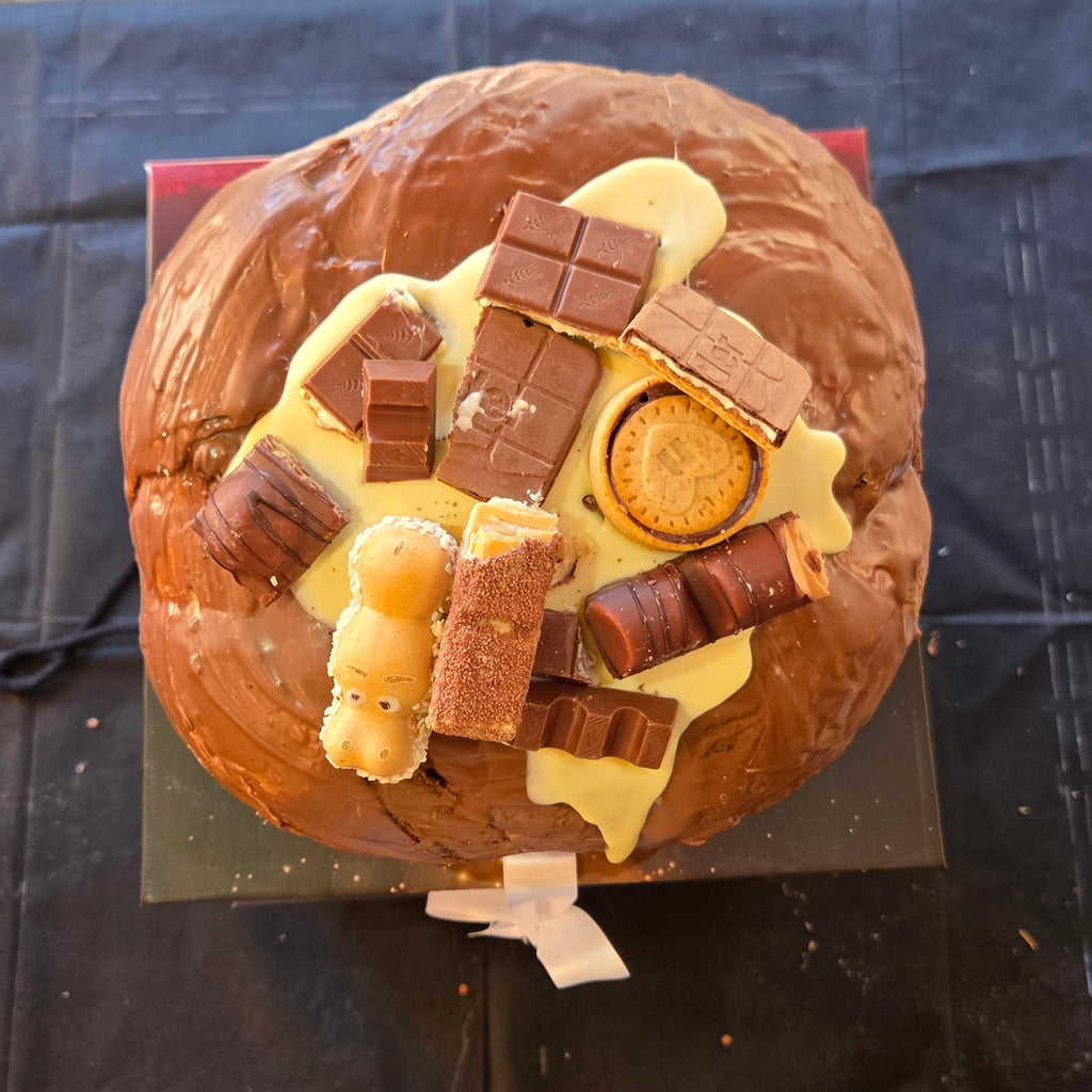 Vista dall'alto del panettone alla nocciola decorato con snack al cioccolato, biscotti e Happy Hippo