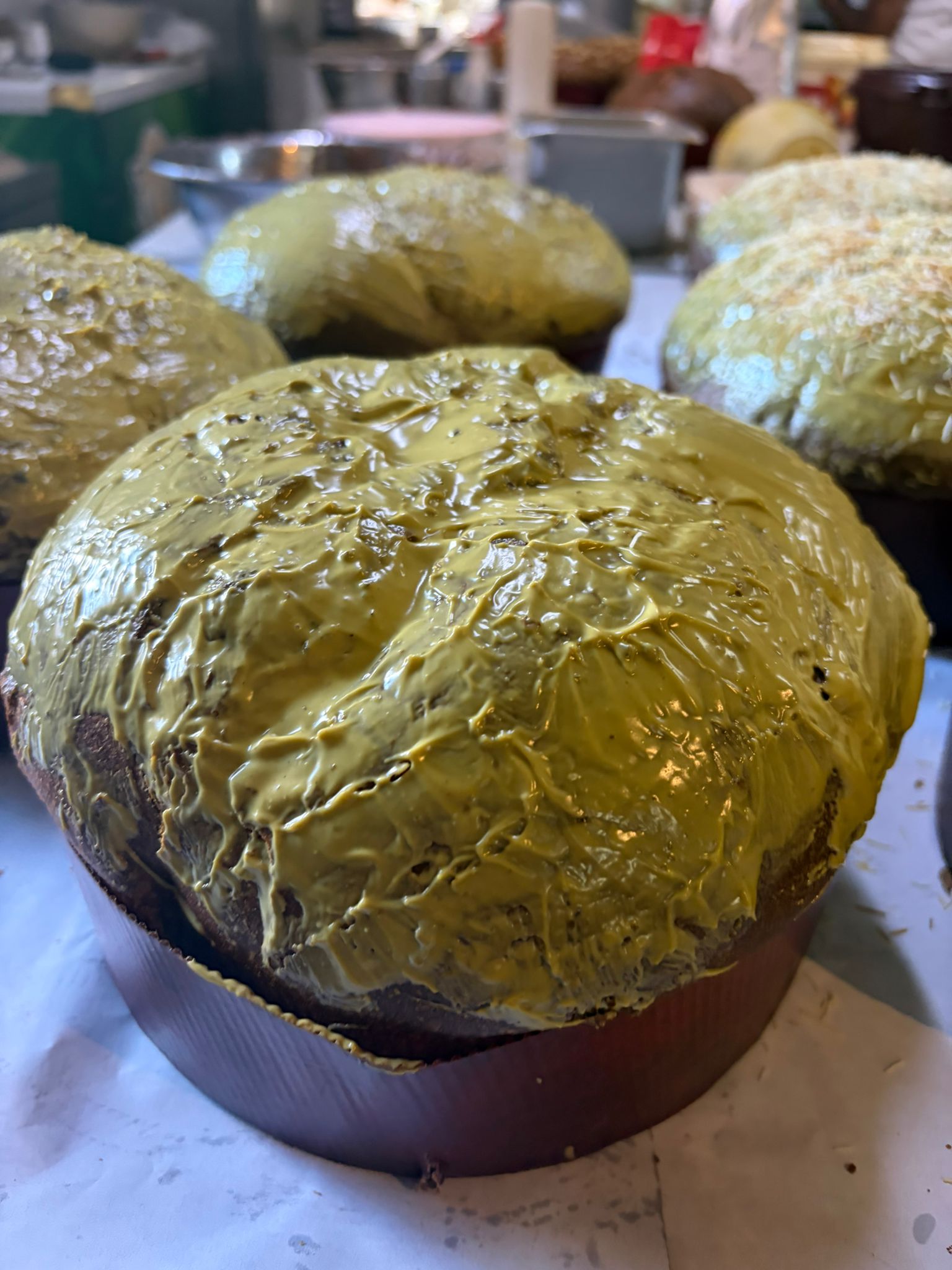 Panettoni al pistacchio artigianali appena glassati in laboratorio